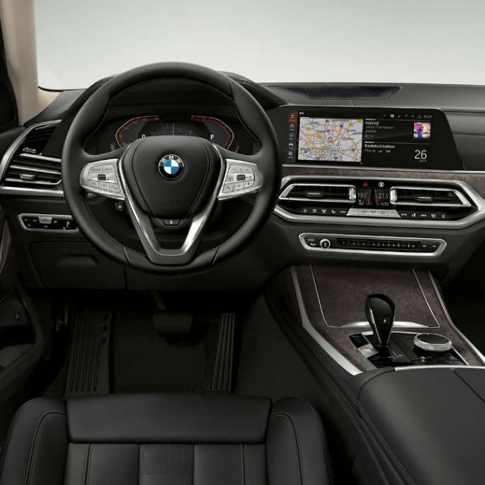 BMW X7 standartaprīkojums BMW X7 uzņēmums studijā, no priekšpuses trīs ceturtdaļu skatā, Vermont bronzas krāsā,Frontal close-up of the driver's cockpit of the BMW X7 with standard equipment features